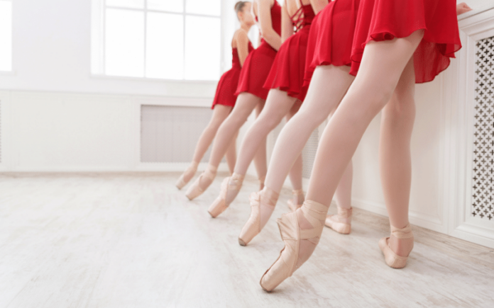 Beautiful dancers on pointe in red ballet skirts